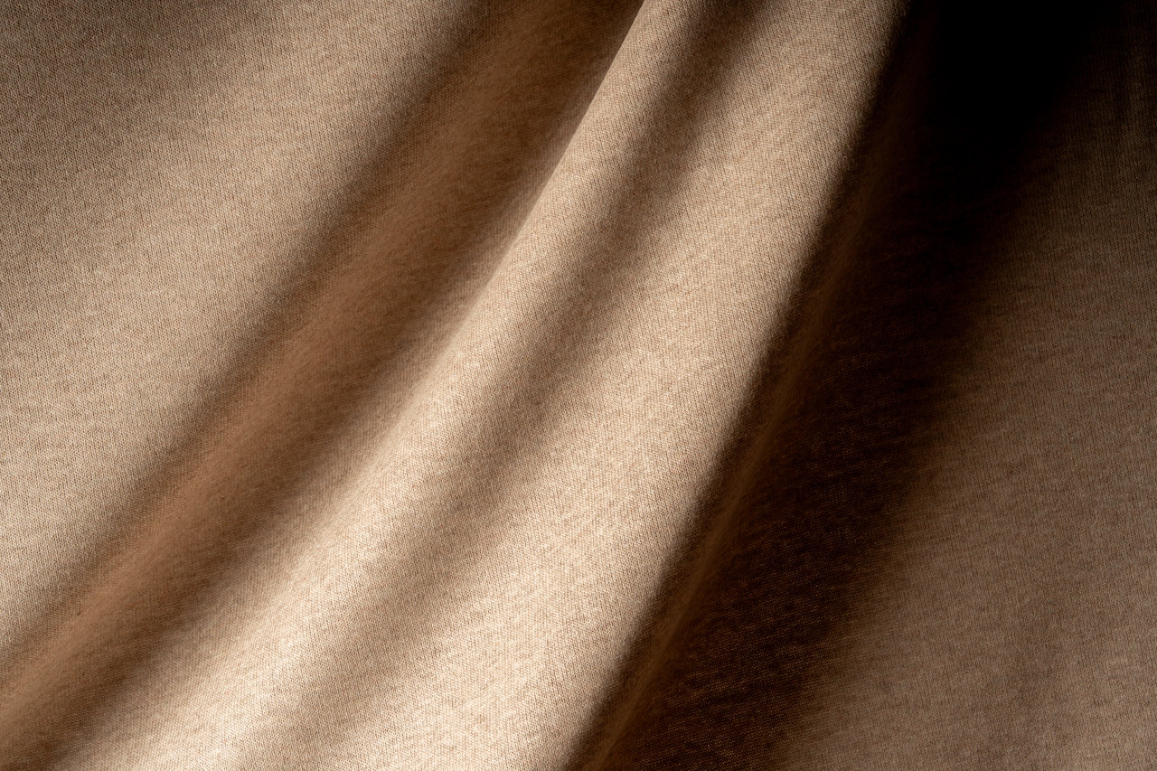 Le pieghe morbide di un tessuto beige, controluce