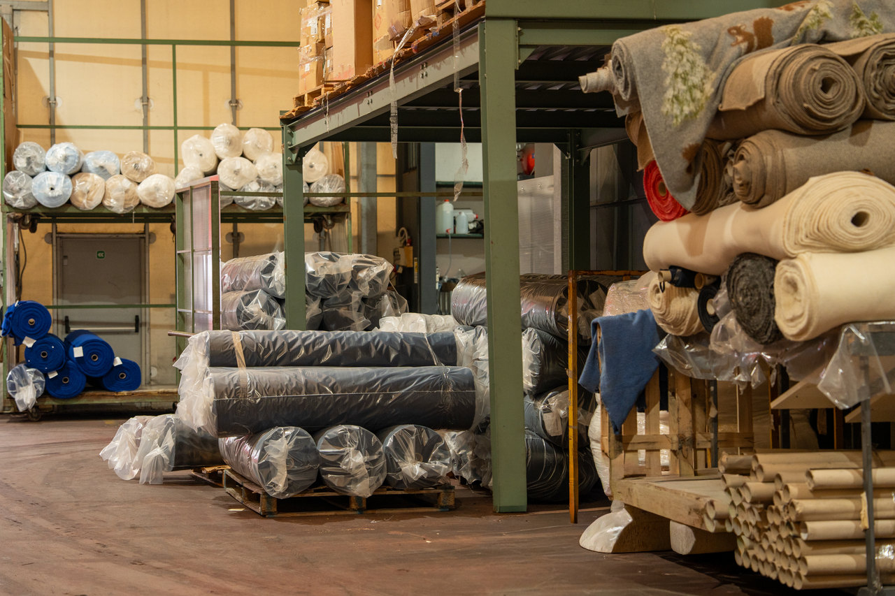 Il magazzino di EvolutionteX: rotoli di tessuto sugli scaffali e pezze imballate sui pallet