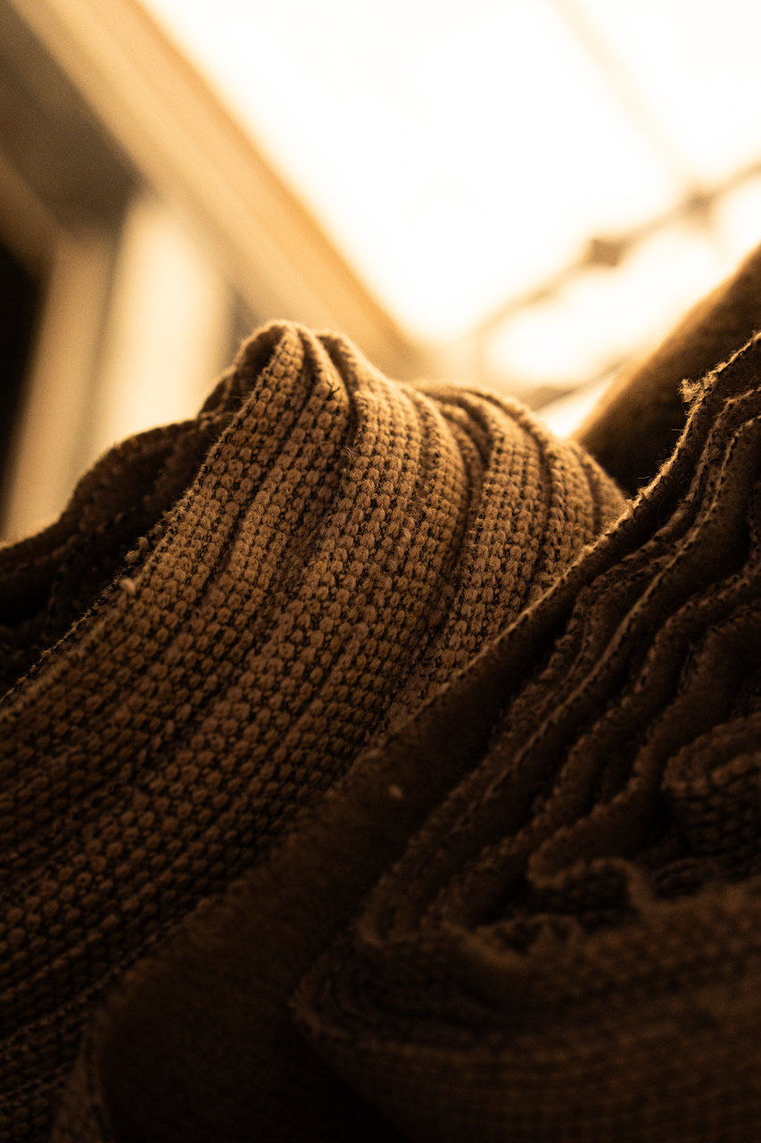 Macro di una maglia marrone in controluce, il punto in rilievo
