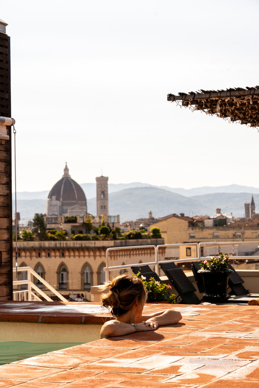 Una ragazza nella piscina sul tetto dell'Hotel Kraft guarda il Duomo di Firenze