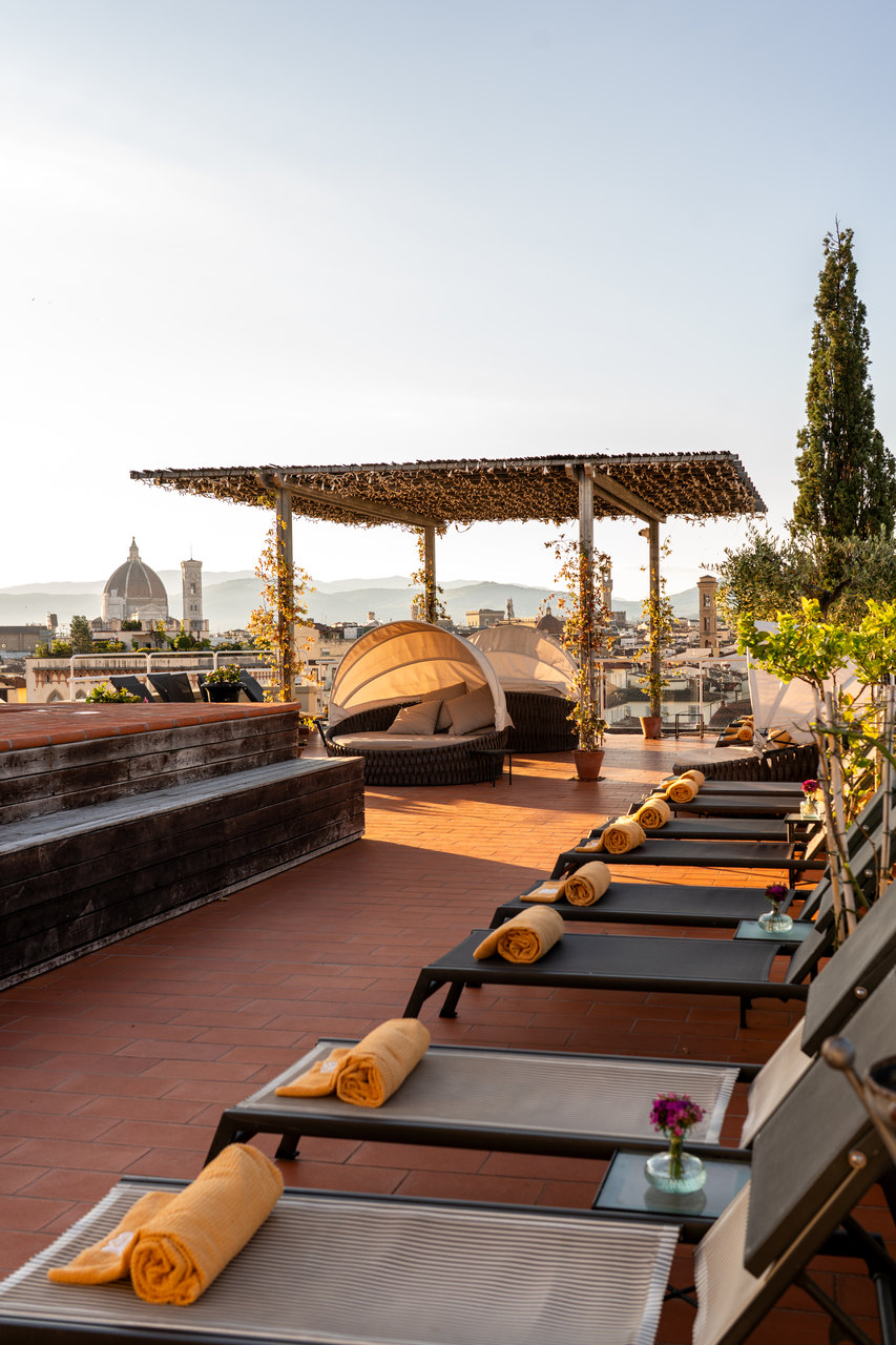 I lettini con gli asciugamani arancioni sulla terrazza della piscina