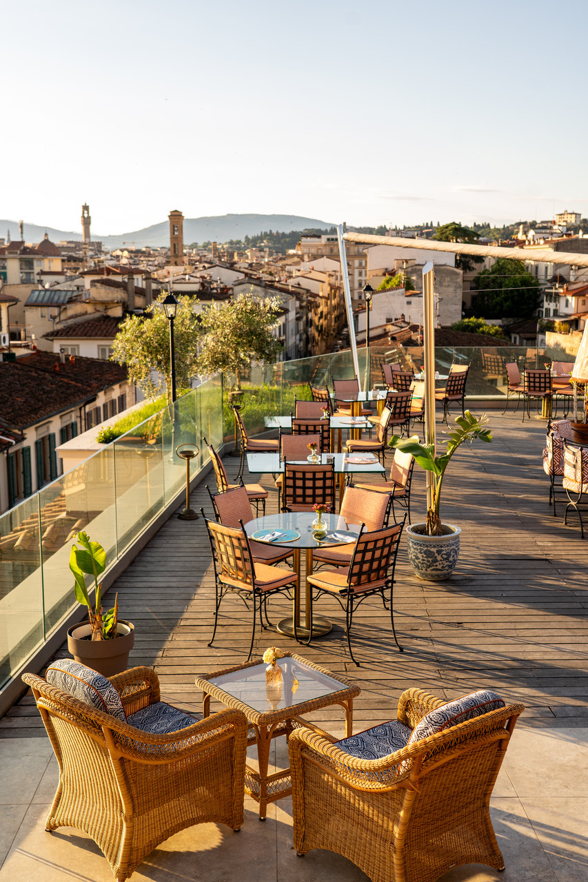 La terrazza con le poltrone di vimini e la vista sui tetti e sulle torri di Firenze
